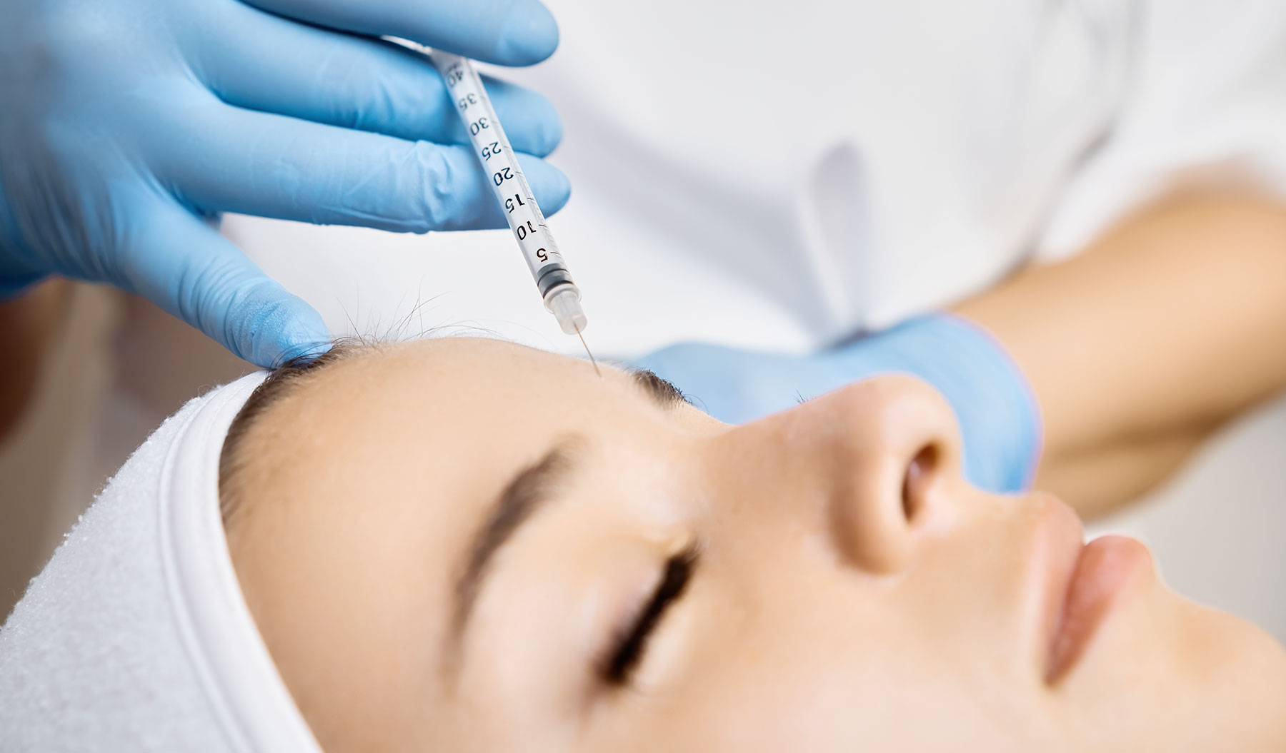 Lady getting botox treatment on her forehead