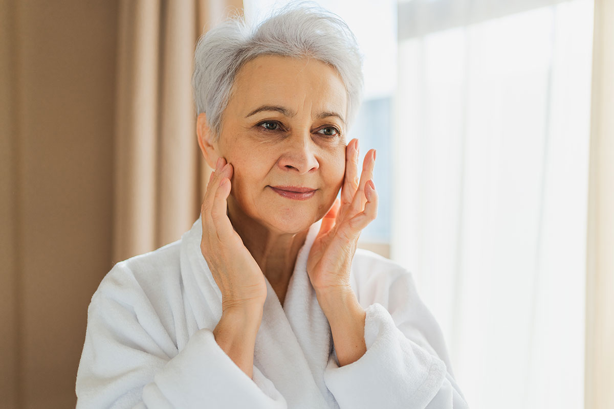 Older lady staring at her face in the mirror