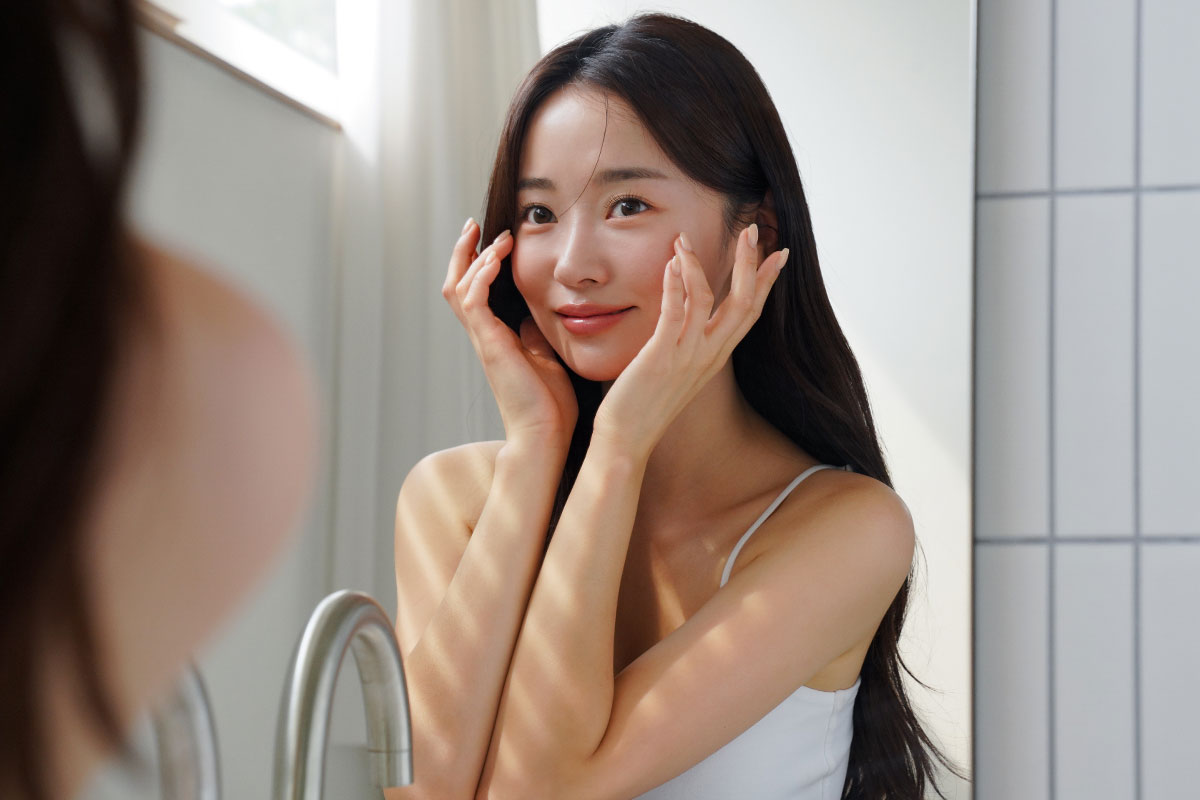Asian lady admiring her face in the mirror
