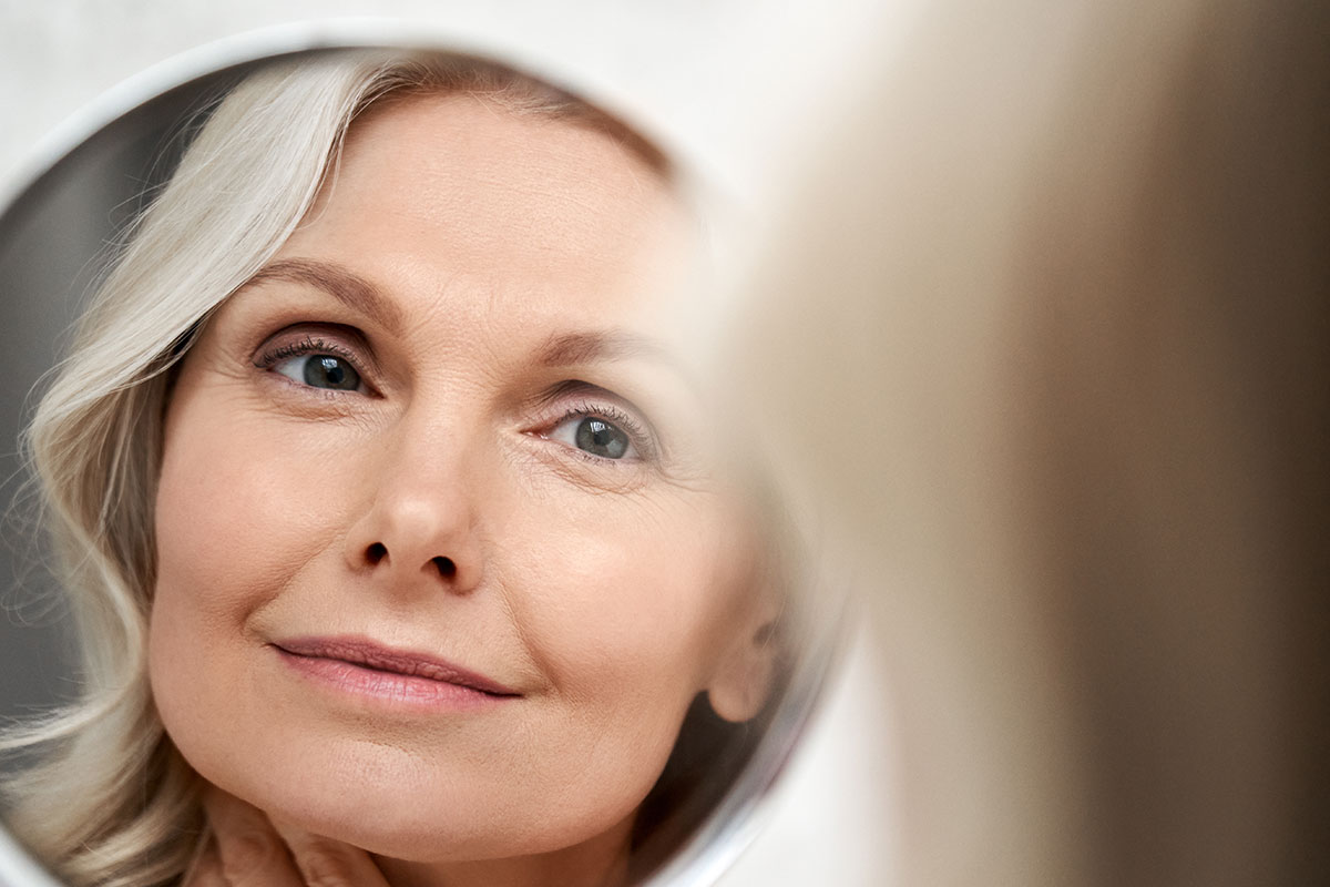 Blonde lady looking at herself in the mirror