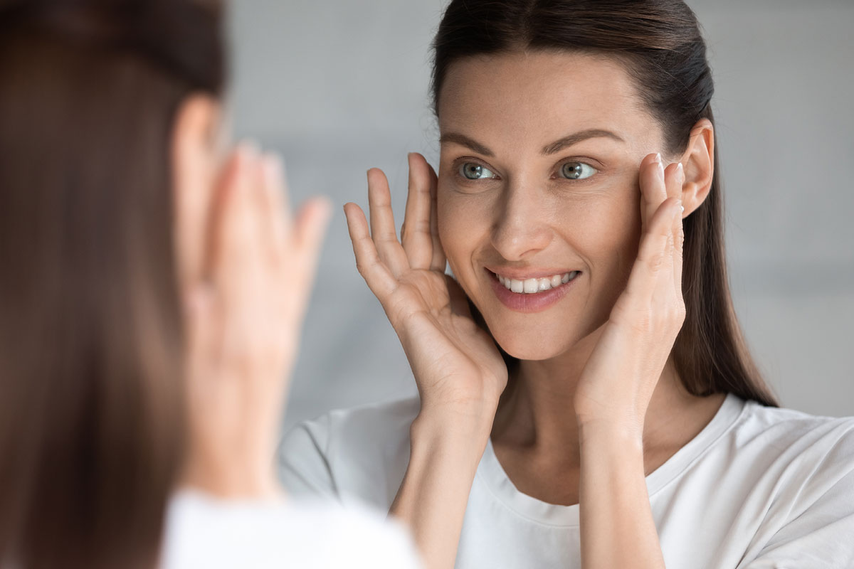 Bruenette lady looking at her new appearance in the mirror