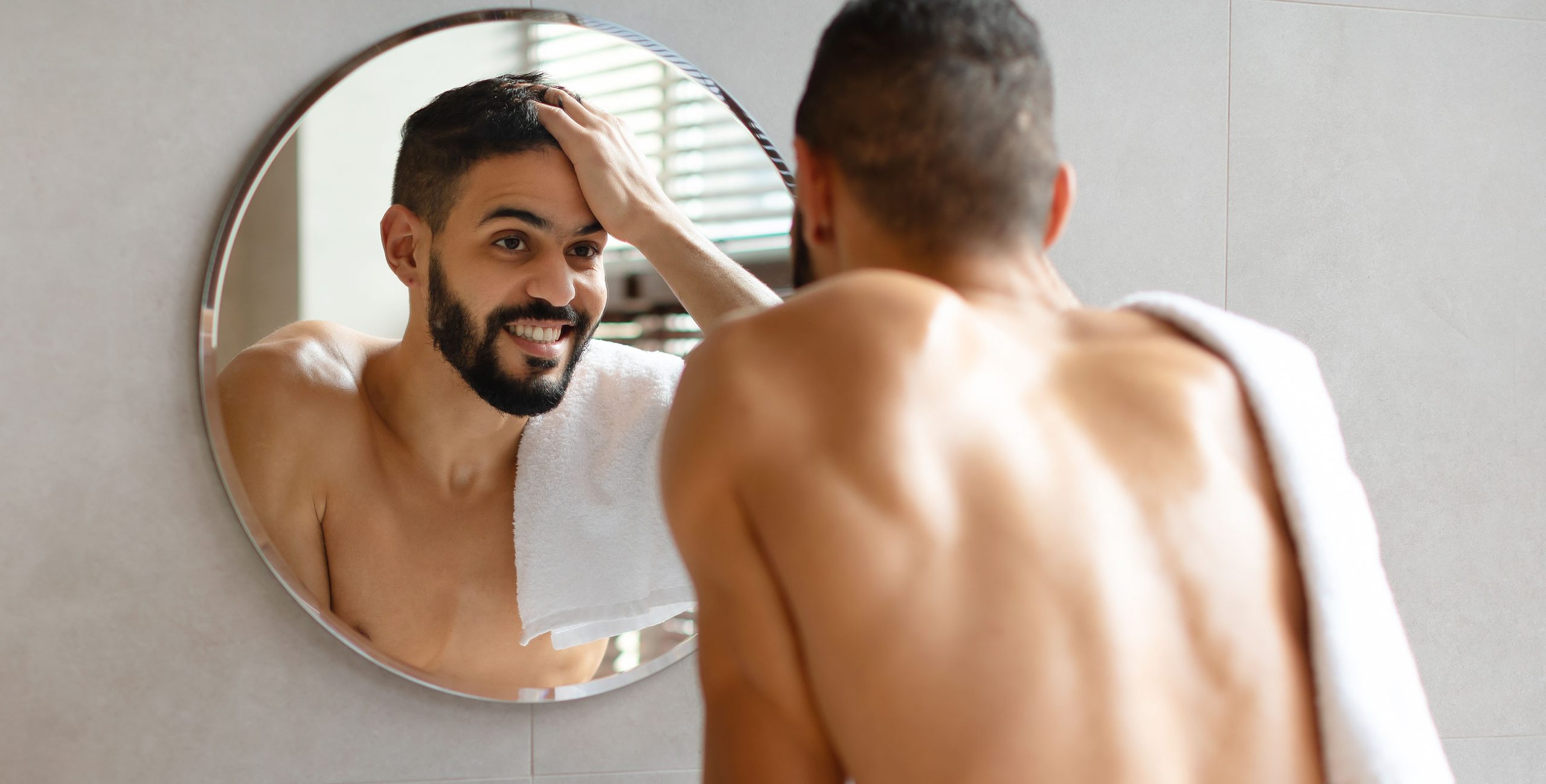 Male looking at his flawless face in the mirror